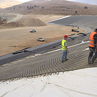 Gli operai addetti alla costruzione posano e riempiono il materassino di calcestruzzo con punto di filtraggio Incomat®.