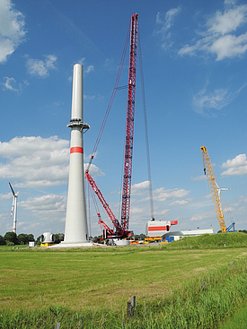Una gru solleva la gondola motore sulla turbina eolica