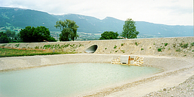Bacino di accumulo delle acque piovane impermeabilizzato con materassi in calcestruzzo e rivestito con massi ciclopici