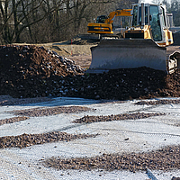 Bulldozer al lavoro, spargendo macerie in un cantiere edile